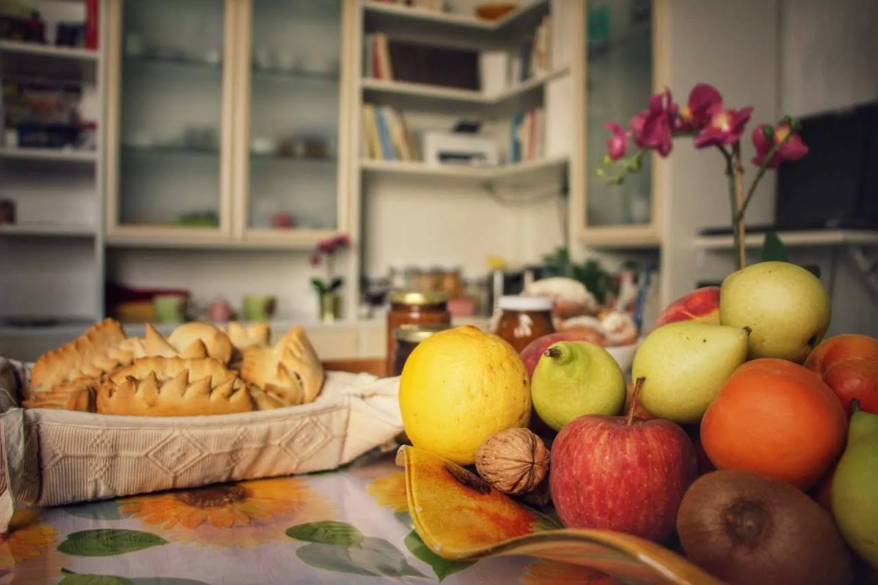 Cesto di frutta fresca, pane e dolci sul tavolo della colazione